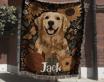 May include: A woven throw blanket featuring a golden retriever illustration centered among sunflowers, roses, and butterflies on a black background. The name Jack is printed in white script at the bottom. The blanket has a fringed edge on all sides.
