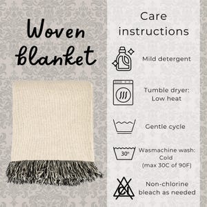 Pu&ograve; includere: Una coperta tessuta color beige con frange nere sul bordo inferiore. L'immagine include il testo: Woven blanket, Care instructions, Mild detergent, Tumble dryer: Low heat, Gentle cycle, Wasmachine wash: Cold (max 30C of 90F), Non-chlorine bleach as needed.