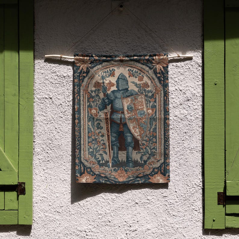 K&ouml;nnte beinhalten: Ein Wandbehang mit einem Ritter in voller R&uuml;stung, der ein Schwert und einen Schild h&auml;lt. Der Wandbehang hat einen detaillierten floralen Rand in Blau-, Beige- und Gr&uuml;nt&ouml;nen. Er h&auml;ngt an einer wei&szlig;en Stuckwand mit gr&uuml;nen Fensterl&auml;den.