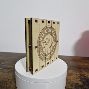 May include: A wooden sign with a circular design featuring a cartoon character with the text "No Coffee No Workie".