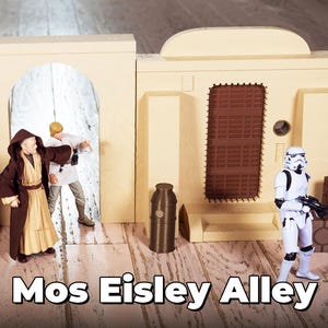 Könnte beinhalten: Ein Star Wars-Spielset mit einem beigefarbenen Gebäude mit einer braunen Tür und einer weißen Sturmtruppen-Figur. Das Set enthält außerdem zwei Figuren in braunen und beigen Roben sowie eine braune und beige Dose.