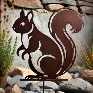 May include: A rusty brown metal squirrel silhouette garden stake. The squirrel is facing left with its tail curled around its body.