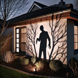 Puede incluir: Una escena de Halloween espeluznante con una sombra de zombi proyectada sobre la pared de una casa. La sombra está rodeada de sombras de ramas de árboles. La escena está iluminada por luces exteriores, creando un efecto dramático.