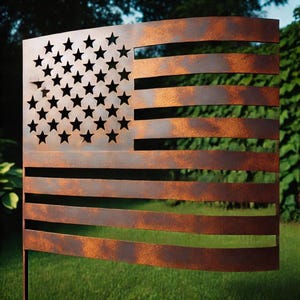 Puede incluir: Una bandera americana de metal oxidado con un aspecto desgastado y descolorido. La bandera está recortada con un diseño de estrellas y rayas. La bandera se muestra al aire libre contra un fondo verde.