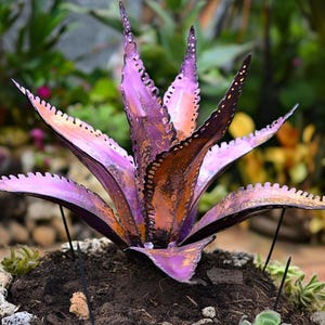 Peut inclure: Une sculpture en métal d'une plante d'agave violette et orange. La sculpture est faite de fines feuilles de métal et présente un design détaillé et réaliste.