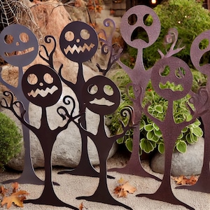 May include: A set of seven black metal Halloween yard decorations shaped like spooky trees with different facial expressions.