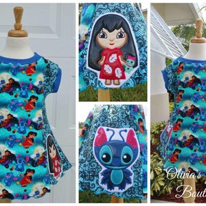 May include: A turquoise and blue dress featuring a pattern of cartoon characters. The dress has a blue neckline and sleeves, with appliqued character designs on the front. The dress is displayed on a mannequin.