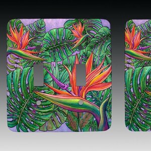 May include: A pair of light switch covers featuring a tropical design with vibrant orange, pink, and green bird of paradise flowers and monstera leaves on a purple background.