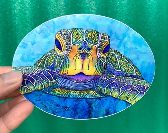 May include: A colorful, detailed illustration of a sea turtle with a blue, green, purple, and yellow shell. The turtle's head is facing the viewer, and its eyes are closed. The background is a light blue watercolor wash.