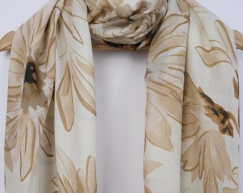 May include: A beige scarf with a brown floral pattern. The scarf is made of a soft, lightweight fabric and is perfect for adding a touch of elegance to any outfit.