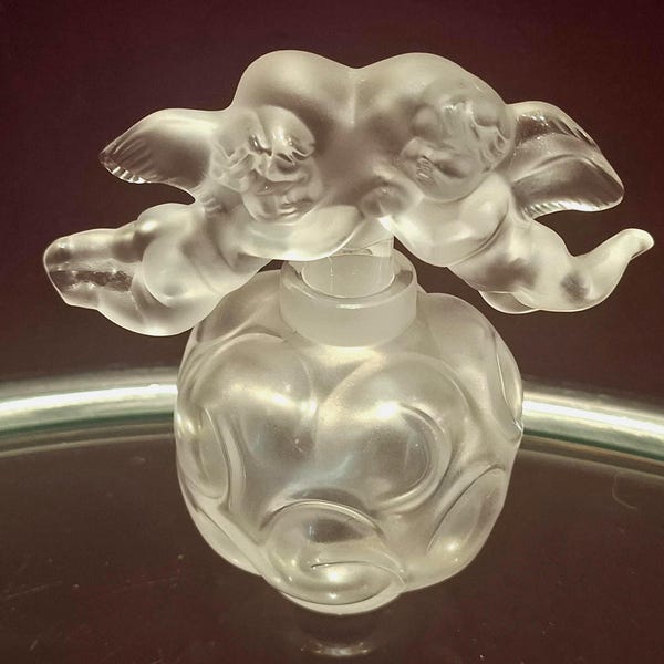 Frasco de perfume Lalique "FLACON NUAGES" con tapón de dos querubines, modelo n.° 11326, firmado por Lalique France en la base.
