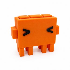 May include: A bright orange, blocky, rectangular figurine with a smooth matte finish. It features two small black chevron-shaped eyes, two side arms, and four short legs. The top surface has three distinct square protrusions aligned in a row.