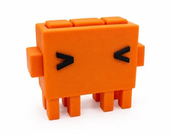 May include: A bright orange, blocky, rectangular figurine with a smooth matte finish. It features two small black chevron-shaped eyes, two side arms, and four short legs. The top surface has three distinct square protrusions aligned in a row.