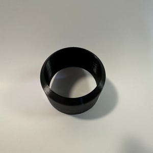 May include: A black plastic ring with a smooth, rounded surface.