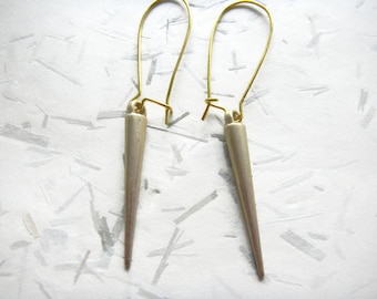 May include: A pair of silver earrings with gold wire hoops and pointed silver tips.
