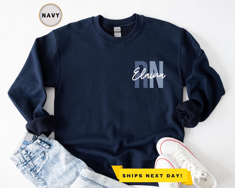 May include: Navy blue sweatshirt with the text "RN Elaina" in white on the front.
