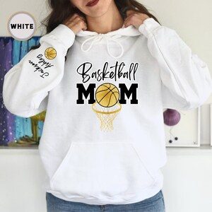 May include: White hoodie with a basketball and the text "Basketball Mom" printed on the front. The hoodie has a drawstring hood and a kangaroo pocket.