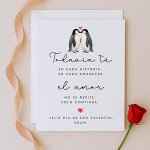May include: A Valentine's Day card with two penguin illustrations, a red heart, and text in Spanish. The text includes phrases like "Todavia tu" and "Feliz Día de San Valentín, Adam."