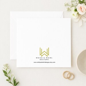 May include: A white square card with the text "WHISK & WHIRL DESIGNS" and a gold logo. The card is placed on a white surface with a white envelope, flowers, and two gold rings. The website address is also visible.