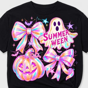 May include: A black t-shirt featuring a colorful graphic print of a ghost, a jack-o'-lantern, and two large bows. The ghost has the text "SUMMER WEEN" in pink letters. The design includes small stars, bats, and spiderwebs in shades of pink, blue, and orange.