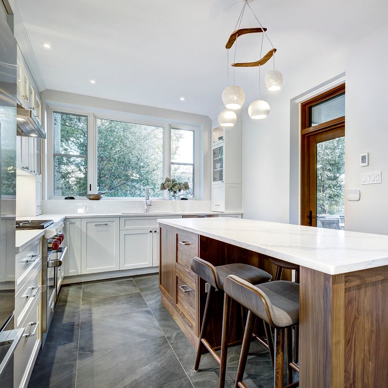 The boomerang large hangs above the island of a new kitchen. Dominated by  white cabinets and wood accents, it fits right in. The fixture's soft curves are a much needed reprieve from the room's many 90 degree angles.