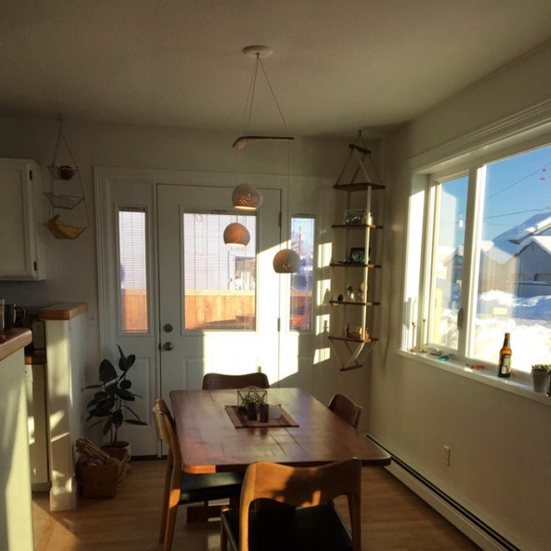 The Boomerang Three hangs above a wooden Scandinavian kitchen table. Light pours in.