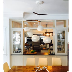 The curves of the boomerang offer a nice reprieve from the many sharp angles of the modern space. The wood boomerangs compliment the wooden table, while the matte ceramic matches the white walls and cabinetry, providing cohesion to the space.