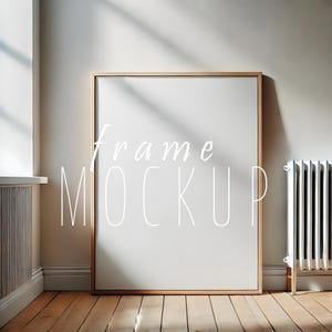 Peut inclure: Une maquette de cadre en bois clair de grande taille avec un fond blanc. Le cadre est posé sur un sol en bois clair. Le texte "frame mockup" est écrit en blanc sur le cadre.