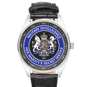 May include: A silver wristwatch with a black leather band. The watch face features a blue and black design with the text "MILITARY INTELLIGENCE" and "HER MAJESTY'S SECRET SERVICE". The watch has a round face with a silver bezel.
