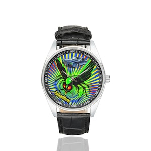 May include: A silver wristwatch with a black leather strap. The watch face displays a green hornet graphic with red eyes and a blue car against a colourful radial backdrop. The text on the watch face reads "The Green Hornet."