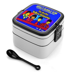 May include: A white and black lunch box with a black spoon. The lunch box has a blue lid with the text "ANGLO BUBBLE GUM" and "The Beatles Yellow Submarine" with images of the band members. The text "BIG 6D PACK" is also visible.