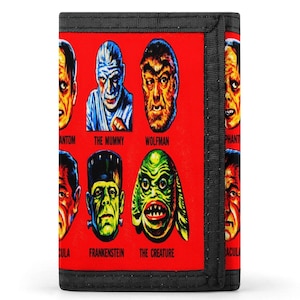 May include: A red bi-fold wallet featuring classic monster faces, including The Mummy, Wolfman, and Frankenstein. The wallet has a black border and includes the names of the monsters below their images. A unique accessory for fans of vintage horror.