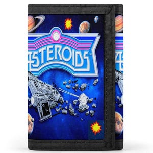 Puede incluir: Una cartera negra de tres pliegues con un diseño de temática espacial. La cartera tiene un fondo azul con planetas, estrellas y una nave espacial. La palabra "Asteroids" se muestra en una fuente retro.