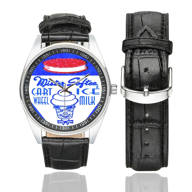 K&ouml;nnte beinhalten: Silberne Armbanduhr mit schwarzem Lederarmband und einem separaten Bandteil. Das Zifferblatt zeigt ein blau-wei&szlig;es Mister Softee-Design mit den Worten "Mister Softee CART WHEEL ICE MILK".