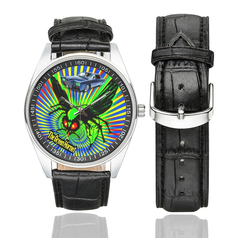 May include: A wristwatch with a black leather strap and a silver case. The watch face displays a green insect with red eyes and a blue car against a colourful radial background. The text "The Green Hornet" is also visible on the watch face.