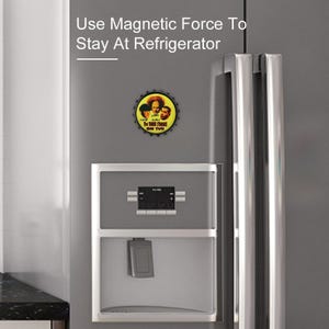 May include: A round bottle cap magnet featuring the Three Stooges. The magnet is attached to a refrigerator. The text on the magnet reads "MOE CURLY The THREE STOOGES ON TV!!" and "Use Magnetic Force To Stay At Refrigerator".