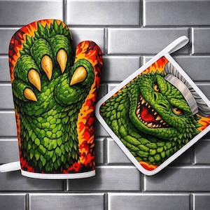 May include: An oven mitt and a square pot holder featuring a green reptilian claw with sharp yellow talons and a green reptilian face wearing a white chef hat, both set against a vibrant orange and yellow flame background with white trim.