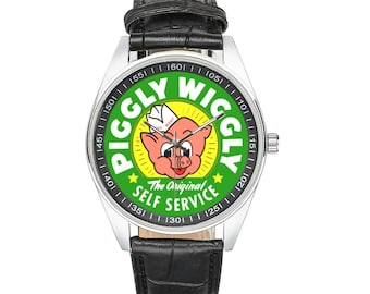 May include: A wristwatch with a silver case and a black leather band. The watch face features a green background with the words "PIGGLY WIGGLY" in yellow and a cartoon pig. The text "The Original Self Service" is also visible.