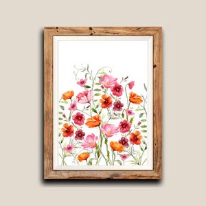 Puede incluir: Impresión artística floral en acuarela enmarcada, con una vibrante variedad de flores rosas, rojas y naranjas con follaje verde. La obra de arte está enmarcada en un marco de madera marrón claro, creando una estética natural y artística. Las flores están sobre fondo blanco.