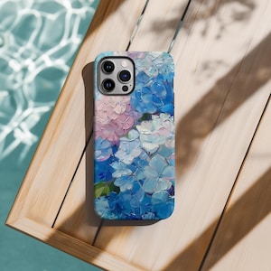 May include: A phone case with a floral design featuring blue and pink hydrangeas painted in a textured style.