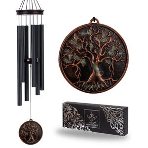 May include: A black wind chime with bronze accents, featuring a tree of life design on the circular pendant and decorative elements. The set includes a matching tree of life wall hanging and a black box with silver floral patterns and the text "Wind Chimes".