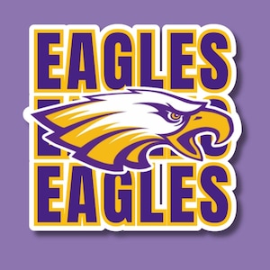 May include: A sticker featuring the word "EAGLES" in purple and yellow block letters. A white eagle head with yellow and purple accents is centered on the sticker. The background is a solid light purple.
