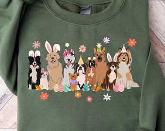 May include: A green sweatshirt with a graphic of dogs wearing bunny ears and party hats. The dogs are surrounded by flowers and Easter eggs.
