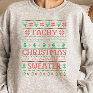 May include: Gray Christmas sweater with a red and green design. The sweater has the text "Tachy Christmas Sweater" on it.