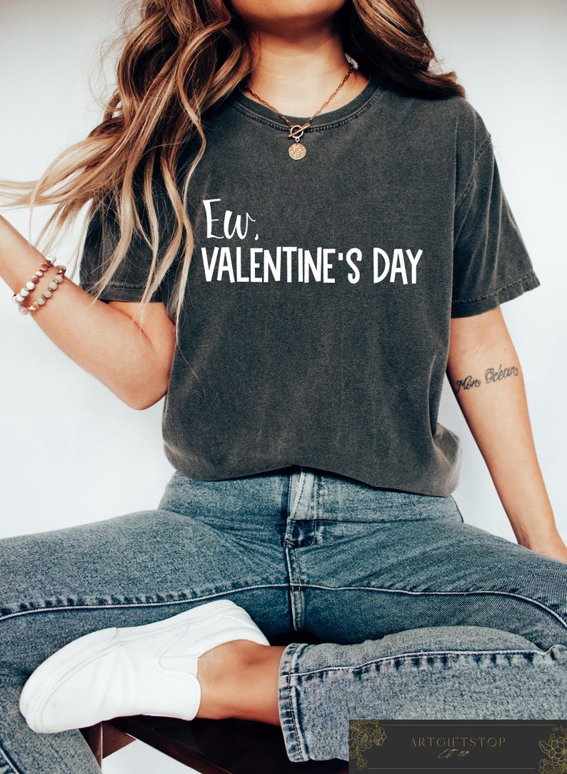 May include: A dark grey t-shirt with the text "Ew. Valentine's Day" printed in white.