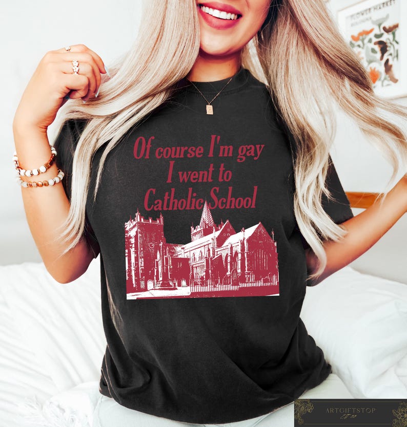 May include: Black t-shirt with a red graphic print of a church and the text "Of course I'm gay I went to Catholic School."