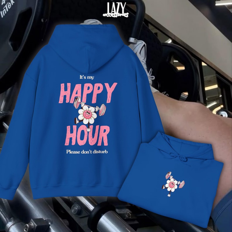May include: A royal blue hoodie with the text "It's my HAPPY HOUR" in pink, featuring a flower lifting weights. The phrase "Please don't disturb" is below. A second hoodie is visible.