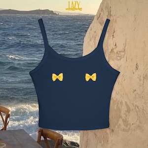 May include: A navy blue tank top with a cropped length. The tank top has two yellow bowtie pasta shapes on the front.