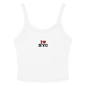 May include: White crop top with thin straps. The top features the text "I ♥ NYC" in black letters with a red heart symbol. The top is made of a soft, ribbed material.