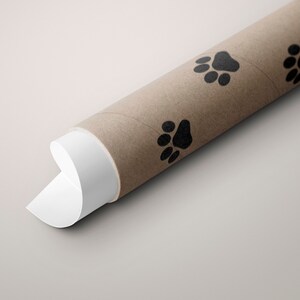 May include: A brown cardboard tube with a white end, decorated with black paw prints. The tube is rolled up and the white end is partially unrolled.